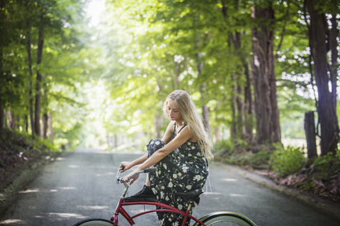 Seitenansicht einer Frau, die auf einem Fahrrad sitzt, lizenzfreies Stockfoto