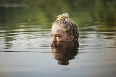 Frau schaut beim Schwimmen im See weg - CAVF08095