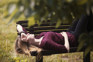 Woman relaxing on bench at park - CAVF08126