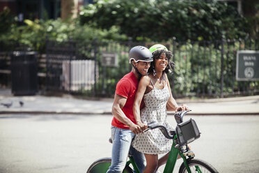 Cheerful couple with bicycle standing on road in city - CAVF08153