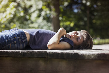 Schlafender Junge auf Veranda im Sonnenlicht - CAVF08178
