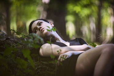 Teenage girl lying in forest - CAVF08184