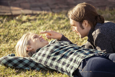 Playful couple spending quality time on grass at park - CAVF08277