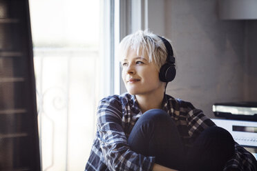 Nachdenkliche Frau hört zu Hause Musik - CAVF08283