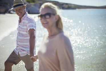 Couple holding hands on beach - CAIF16277