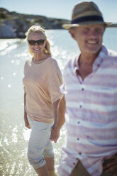 Couple walking in water together - CAIF16289