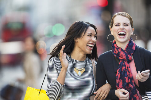Frauen, die lachend durch die Straßen der Stadt gehen - CAIF16294
