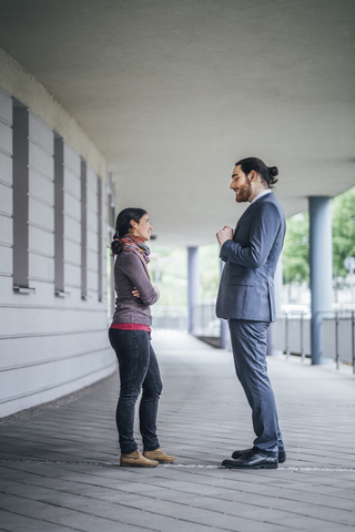 Businessman talking to woman at an arcade stock photo