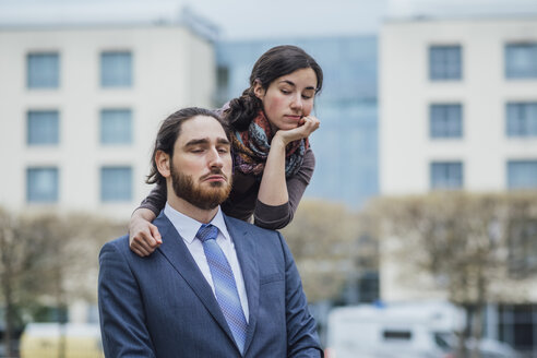 Portrait of displeased businessman and woman outside office building - JSCF00066