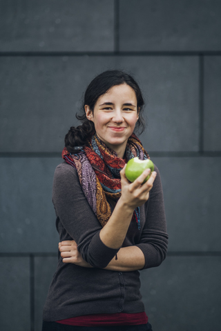 Portrait of smiling woman eating an apple stock photo