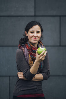 Porträt einer lächelnden Frau, die einen Apfel isst - JSCF00084