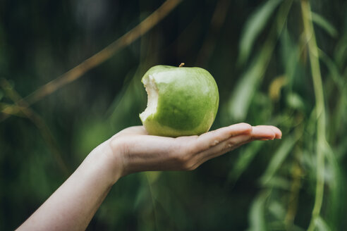 Woman's hand holding bitten apple - JSCF00085