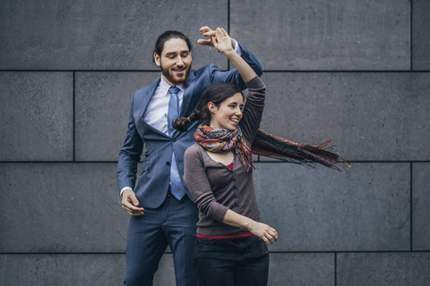Happy businessman and woman dancing outdoors stock photo
