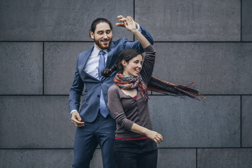 Happy businessman and woman dancing outdoors - JSCF00093