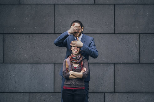 Businessman covering laughing woman's eyes - JSCF00095