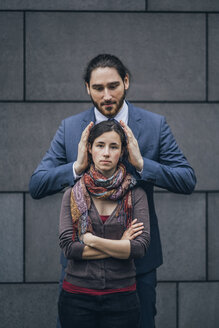 Businessman covering woman's ears - JSCF00096