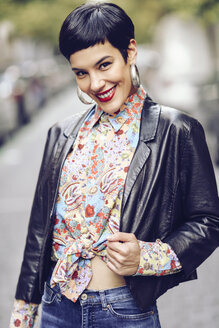 Portrait of fashionable young woman wearing patterned blouse and leather jacket - JSMF00125