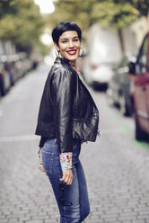 Portrait of fashionable young woman wearing jeans and leather jacket - JSMF00126