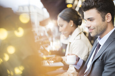 Business people working at sidewalk cafe - CAIF16319