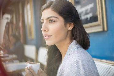 Woman drinking espresso at sidewalk cafe - CAIF16336