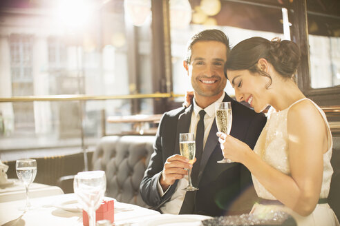 Gut gekleidetes Paar trinkt Champagner im Restaurant - CAIF16338