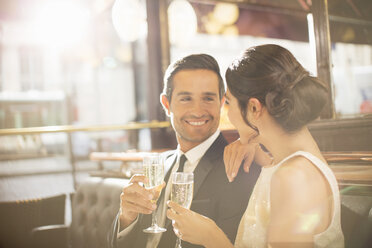 Couple drinking champagne in restaurant - CAIF16344