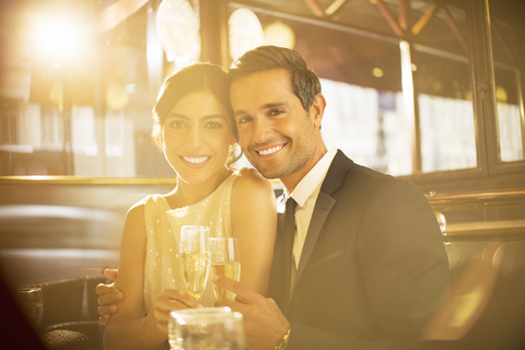 Paar stößt in einem Restaurant mit Champagnerflöten an, lizenzfreies Stockfoto