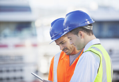 Arbeiter benutzen digitales Tablet in der Nähe von Lastwagen - CAIF16401