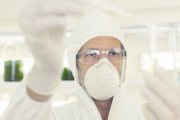 Wissenschaftler in sauberem Anzug mit Pipette und Reagenzglas - CAIF16456
