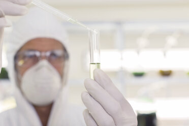 Wissenschaftler im sauberen Anzug mit Pipette und Reagenzglas im Labor - CAIF16479