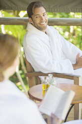 Couple relaxing together in bathrobes - CAIF16537