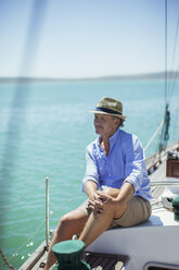 Älterer Mann sitzt auf einem Boot im Freien - CAIF16629