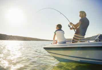 Vater und Sohn fischen auf einem Boot - CAIF16642