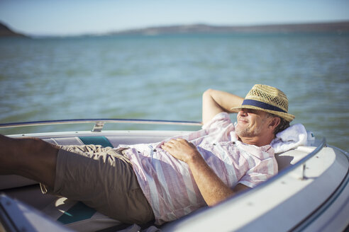Älterer Mann entspannt sich in einem Boot auf dem Wasser - CAIF16645