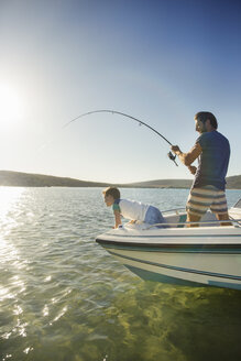 Vater und Sohn fischen auf einem Boot - CAIF16648