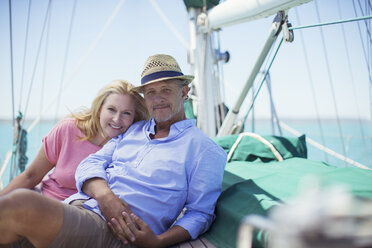 Couple sitting on deck of sailboat - CAIF16655