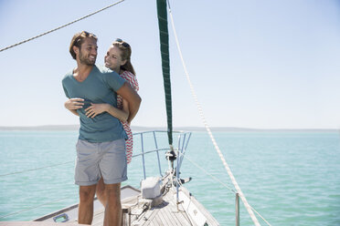 Couple hugging on deck of sailboat - CAIF16674