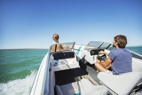 Mann steuert Boot auf dem Wasser mit Freundin - CAIF16679