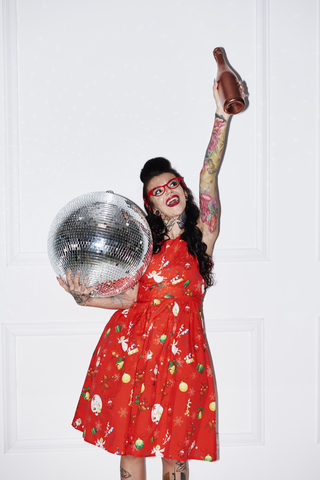 Portrait of tattooed woman with champagne bottle and disco ball stock photo