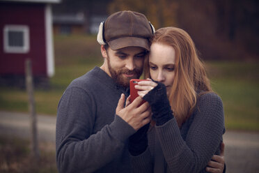 Couple looking at mobile phone - CAVF08350