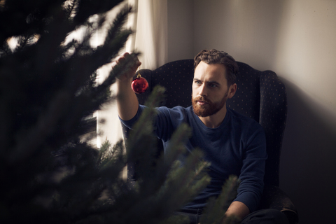 Hohe Winkel Ansicht des Mannes hält Weihnachtsschmuck, lizenzfreies Stockfoto