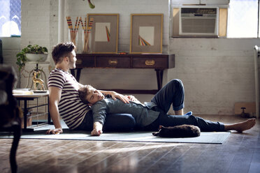 Gay couple relaxing on living room at home - CAVF08394