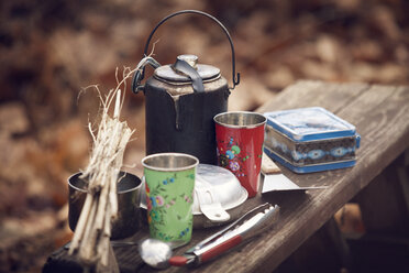 Campinggegenstände auf einer Bank im Wald - CAVF08454