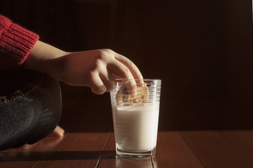Ausgeschnittenes Bild eines Mädchens, das einen Keks in Milch taucht - CAVF08487