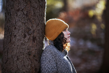 Seitenansicht eines jungen Mädchens, das bei Bäumen im Wald steht - CAVF08535