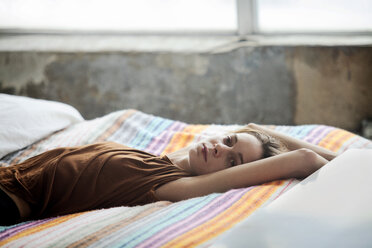 Portrait of woman relaxing on bed at home - CAVF08660