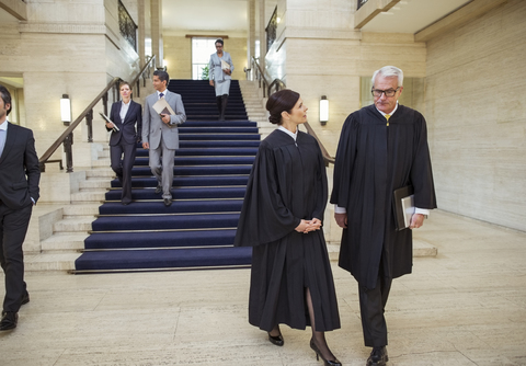 Richter und Anwälte gehen durch das Gerichtsgebäude, lizenzfreies Stockfoto