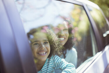 Happy mother and daughter looking out car window - CAIF16905