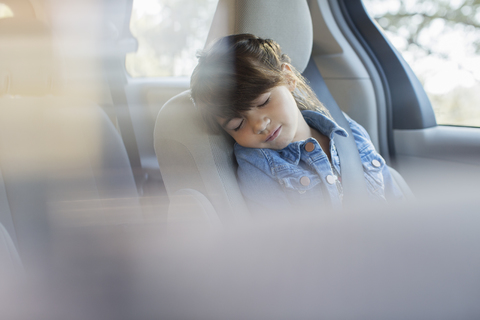 Mädchen schläft auf dem Rücksitz eines Autos, lizenzfreies Stockfoto