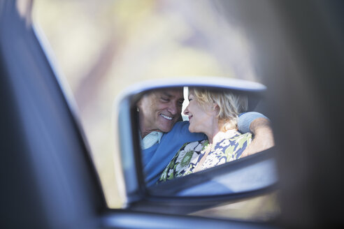 Seitenspiegelreflexion eines sich umarmenden Paares im Auto - CAIF16910